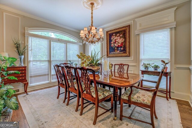 dining room featuring an inviting chandelier, crown molding, and light wood-type flooring