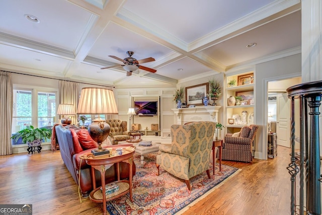 living area featuring ceiling fan, beamed ceiling, coffered ceiling, and wood finished floors