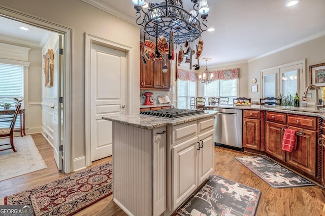kitchen featuring a chandelier, appliances with stainless steel finishes, ornamental molding, and a sink