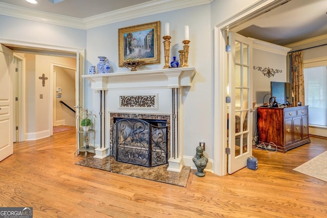 room details with crown molding, a high end fireplace, baseboards, and wood finished floors