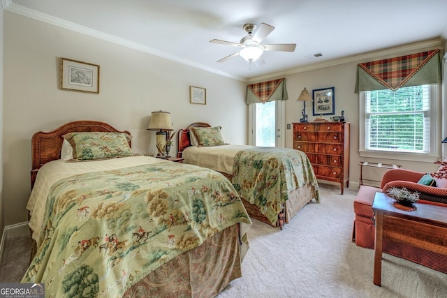 carpeted bedroom featuring crown molding, baseboards, visible vents, and ceiling fan