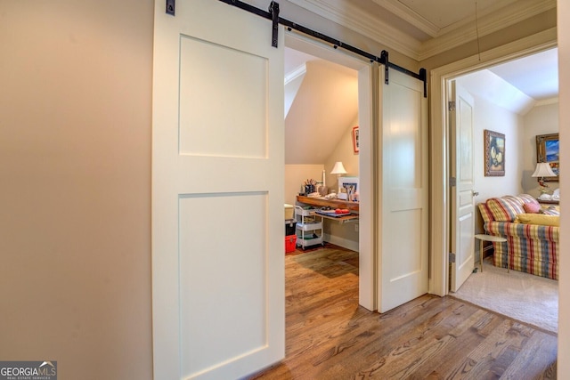 corridor with crown molding, a barn door, lofted ceiling, and wood finished floors