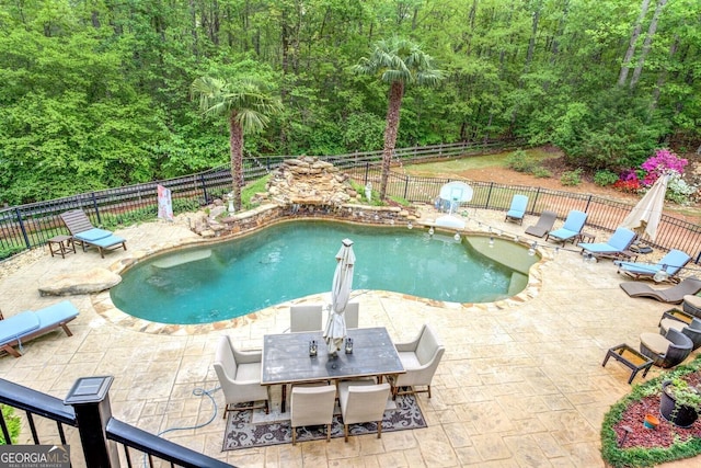view of pool featuring a fenced backyard, a fenced in pool, a patio, and outdoor dining space