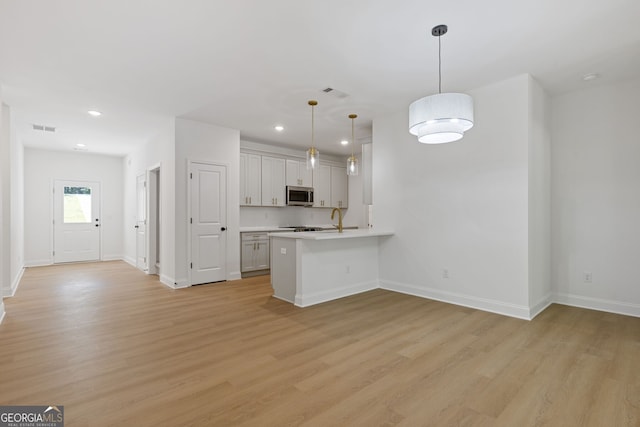 1488 Campbell Rd, Covington, GA 30014 - kitchen featuring visible vents, light countertops, light wood-style flooring, and stainless steel microwave