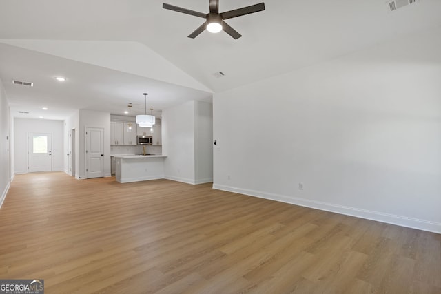 1488 Campbell Rd, Covington, GA 30014 - unfurnished living room with vaulted ceiling, baseboards, a ceiling fan, and light wood-type flooring