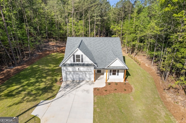 1488 Campbell Rd, Covington, GA 30014 - view of front of home featuring driveway, roof with shingles, a garage, a wooded view, and a front lawn