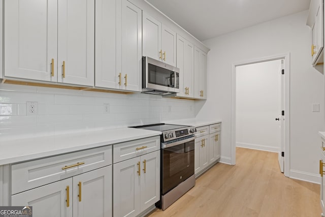 1488 Campbell Rd, Covington, GA 30014 - kitchen with light countertops, appliances with stainless steel finishes, decorative backsplash, and light wood-style floors