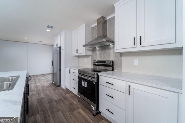 92 Wood Duck Ln, Folkston, GA 31537 - kitchen featuring wall chimney range hood, appliances with stainless steel finishes, white cabinetry, dark wood-type flooring, and visible vents