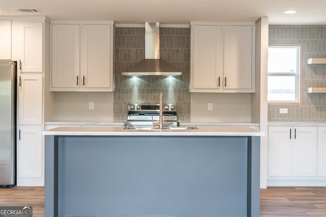 92 Wood Duck Ln, Folkston, GA 31537 - kitchen with wall chimney range hood, backsplash, a sink, stainless steel appliances, and an island with sink