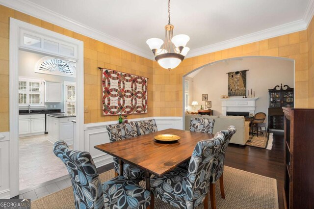 5 Renfroe Ct, Decatur, GA 30030 - dining space featuring crown molding, a chandelier, a fireplace, arched walkways, and a decorative wall