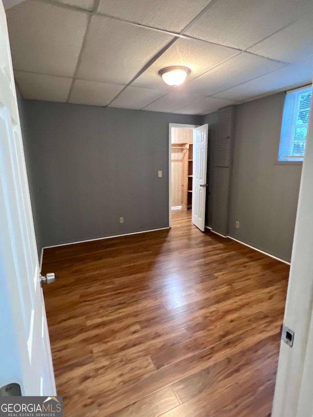 interior space featuring a drop ceiling and wood finished floors