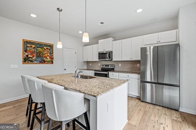 181 Sweet Briar Way, Homer, GA 30547 - kitchen with appliances with stainless steel finishes, white cabinets, a kitchen island with sink, light stone countertops, and tasteful backsplash