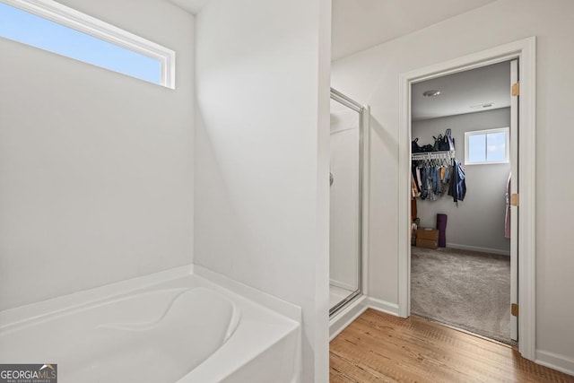 181 Sweet Briar Way, Homer, GA 30547 - full bath featuring a stall shower, a bath, a walk in closet, and wood finished floors