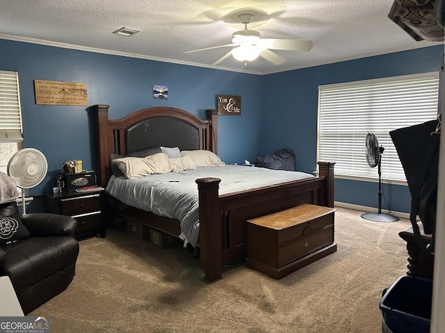 carpeted bedroom with ceiling fan, ornamental molding, a textured ceiling, and visible vents