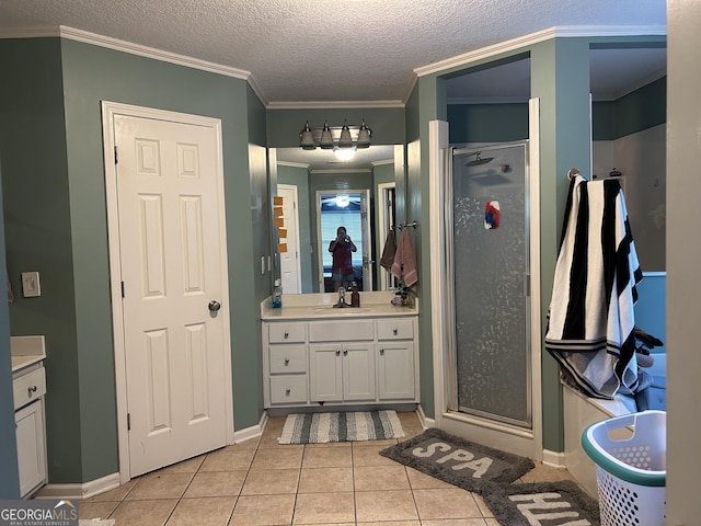 bathroom with a stall shower, baseboards, tile patterned flooring, and vanity