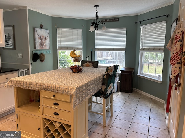 dining space featuring crown molding, baseboards, a notable chandelier, and light tile patterned floors