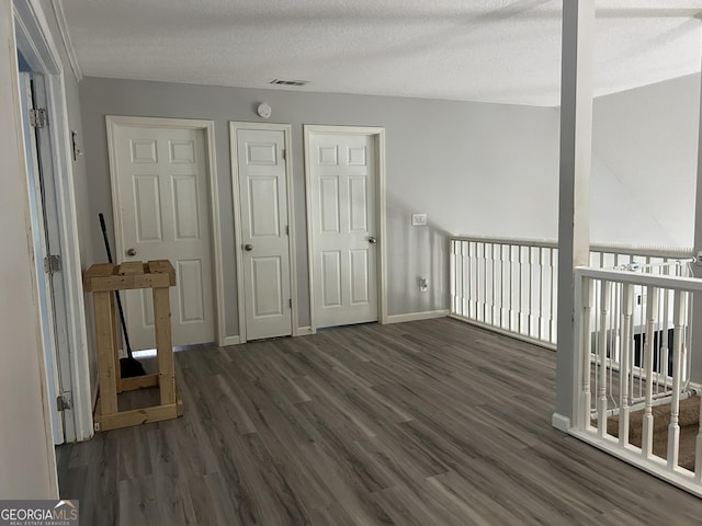 bonus room featuring visible vents, baseboards, a textured ceiling, and wood finished floors