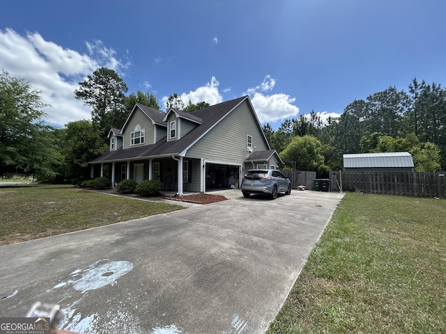 view of home's exterior featuring a lawn, fence, driveway, and covered porch