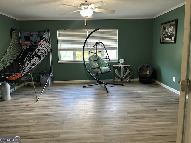 bedroom with a textured ceiling, baseboards, ornamental molding, and wood finished floors