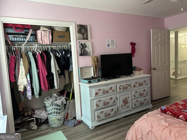 bedroom with wood finished floors and a closet