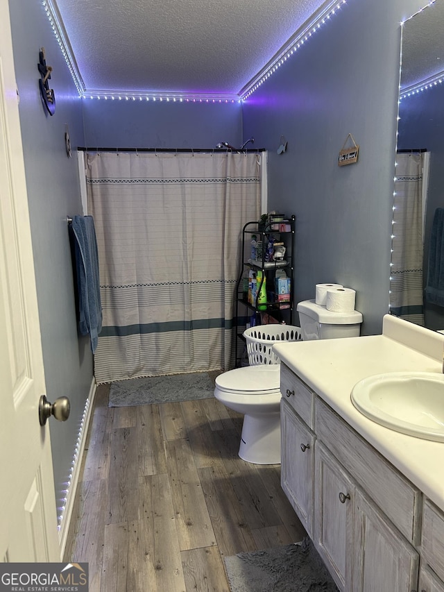 full bathroom with a textured ceiling, wood finished floors, vanity, toilet, and a shower with shower curtain