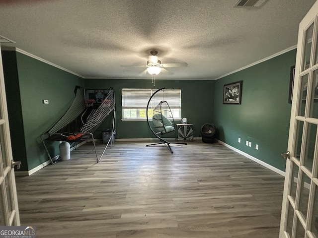 interior space featuring baseboards, ornamental molding, and wood finished floors