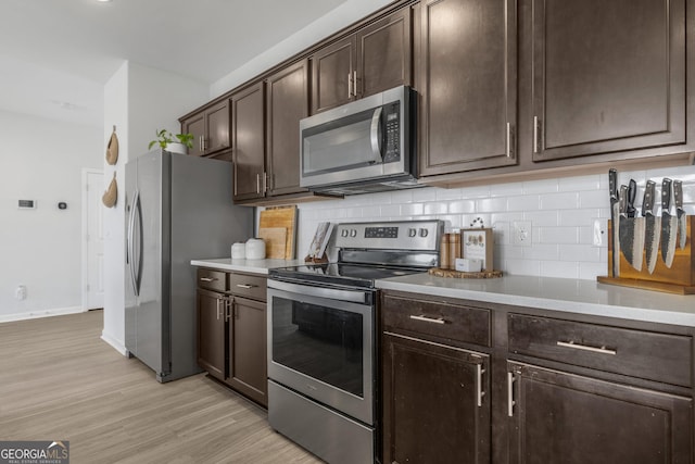 234 Lakepointe Dr, Savannah, GA 31407 - kitchen featuring dark brown cabinetry, light wood finished floors, light countertops, stainless steel appliances, and backsplash