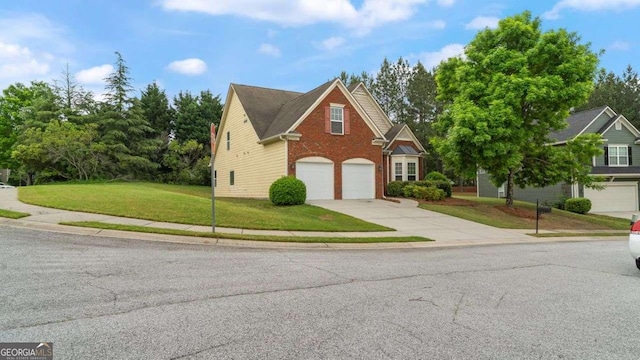 traditional-style home featuring an attached garage, a front yard, driveway, and brick siding