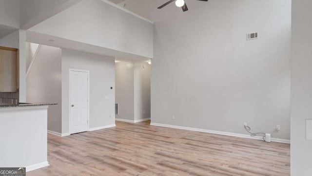 unfurnished living room featuring baseboards, a ceiling fan, light wood-style flooring, and visible vents