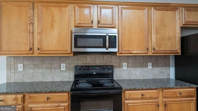 kitchen featuring decorative backsplash, black appliances, and dark stone countertops
