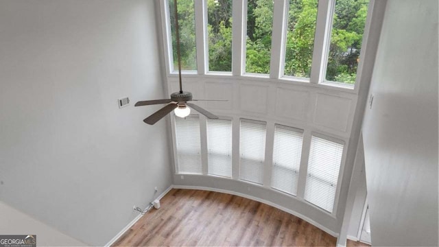 empty room with baseboards, ceiling fan, light wood finished floors, and visible vents