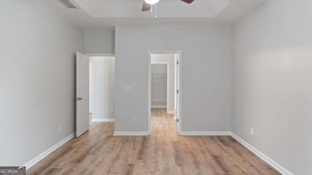 spare room featuring visible vents, a ceiling fan, baseboards, and wood finished floors
