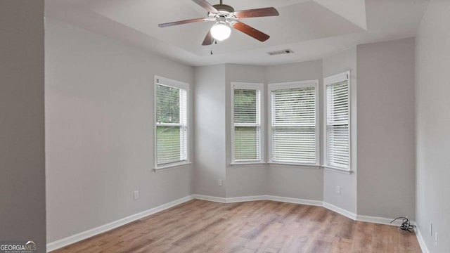 unfurnished room with a ceiling fan, baseboards, visible vents, and light wood-style floors