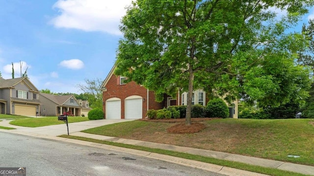 view of property hidden behind natural elements featuring brick siding, an attached garage, driveway, and a front yard