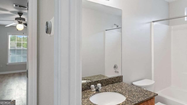 bathroom with vanity, bathtub / shower combination, toilet, a ceiling fan, and wood finished floors