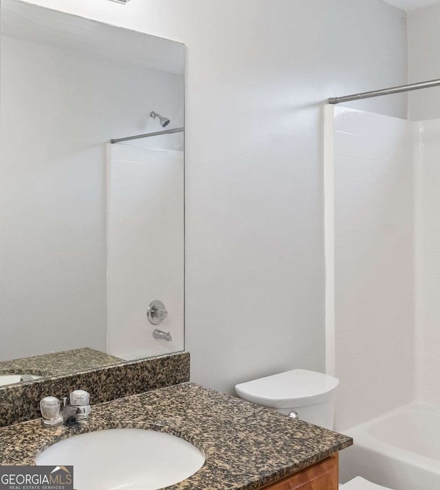bathroom featuring vanity, shower / bath combination, and toilet