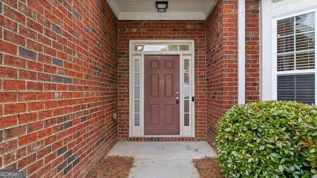 view of exterior entry with brick siding