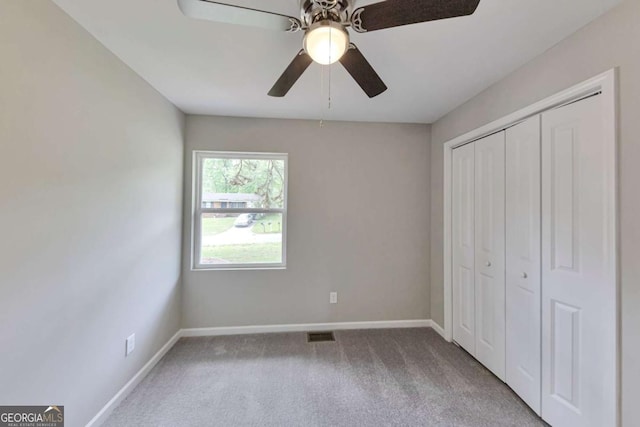 unfurnished bedroom featuring baseboards, carpet, visible vents, and a closet
