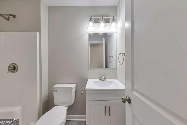 full bath featuring vanity, baseboards, toilet, and a shower