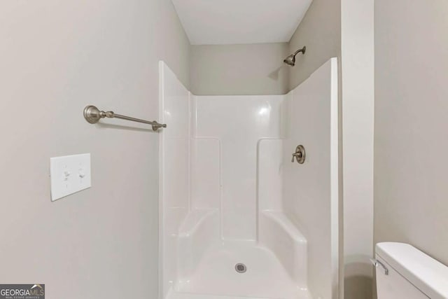 bathroom with toilet and a shower