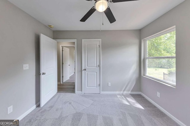 unfurnished bedroom with a ceiling fan, baseboards, and carpet