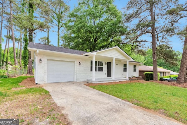 view of front of home featuring covered porch, driveway, a garage, brick siding, and a front lawn