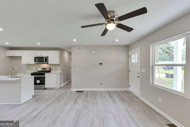 kitchen with visible vents, light countertops, white cabinets, a sink, and stainless steel appliances