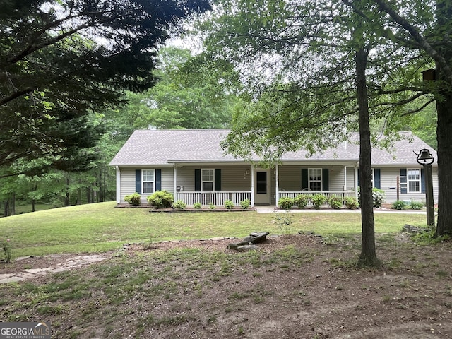 ranch-style home featuring covered porch, a shingled roof, and a front yard