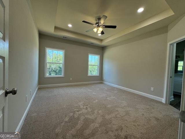 carpeted spare room featuring a ceiling fan, baseboards, recessed lighting, and a raised ceiling