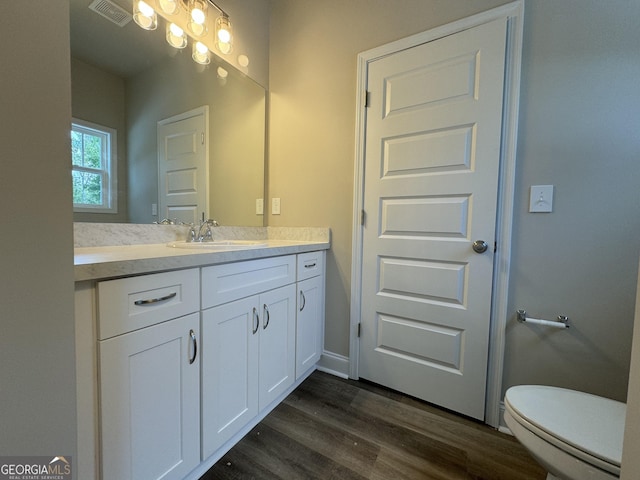 bathroom featuring visible vents, wood finished floors, toilet, and vanity