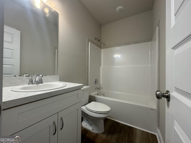 bathroom with vanity, wood finished floors, bathtub / shower combination, and toilet