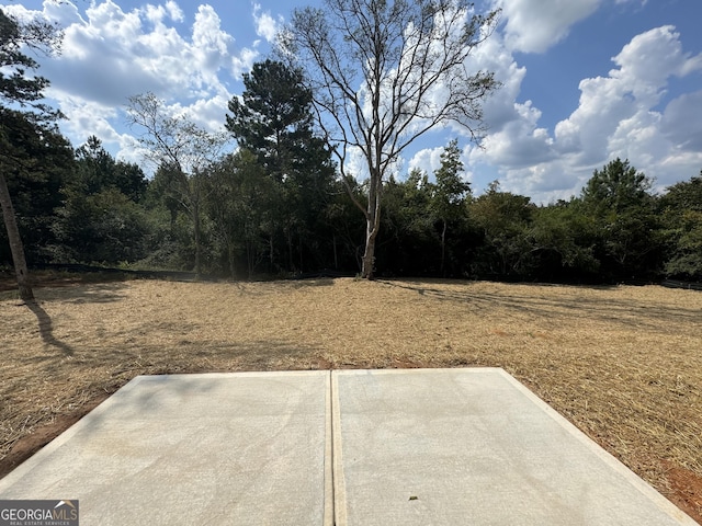 view of yard with a patio area and a wooded view