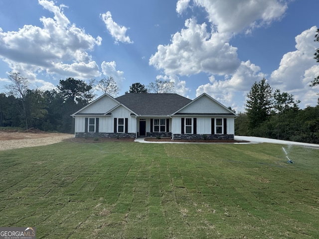 ranch-style home featuring board and batten siding and a front lawn