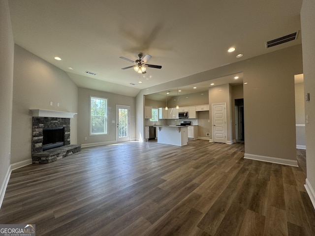 unfurnished living room with baseboards, ceiling fan, dark wood finished floors, and visible vents